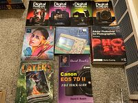 Top view showing nine photography and editing books stacked with visible titles and authors.