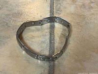 Full view of the Sabona magnetic therapy bracelet laid flat showing the silver stainless steel links with embedded magnets inside.