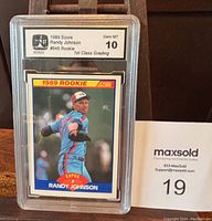 Front view of 1989 Score Randy Johnson rookie card #645 graded 10 Gem Mint, showing player pitching in Expos uniform with grading label at top.