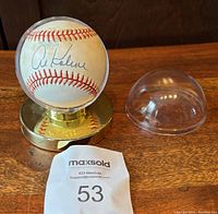 Baseball signed by Al Kaline in a gold-colored display holder, with the clear dome cover removed and placed beside it.