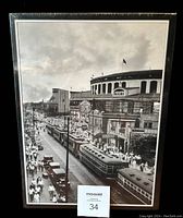 Framed puzzle box front with black and white image of Wrigley Field and surrounding street scene showing crowd, streetcars, and cars.