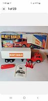 Photo showing the radio controlled heavy hauler semi tractor trailer toy with its original box, remote control, traffic cones, and paperwork arranged in front.