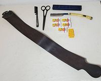Full lot overview showing pigskin razor strop, antique scissors, shavette, blue diamond folding razor with box, and replacement blades spread out