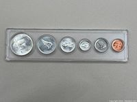 Front side photo of Canadian 1967 coin set showing a series of coins in clear plastic holder including silver dollar and smaller denominations.