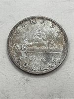 Reverse image showing the canoe design with the year 1959 and inscriptions "CANADA" and "DOLLAR".