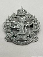 Front view of a vintage metal cap badge featuring a crowned stag head and wreath of maple leaves and thistles with banners reading 'PEEL NASSAU YORK HALTON ELLETT' and '40 ARMY SCOUTS THE LORNE SCOUTS'