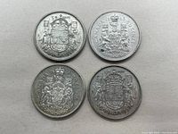 Top view of four Canadian silver 50 cent coins showing two dated 1958, one 1963, and one 1964 with coat of arms side up.