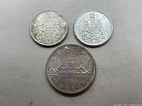 Three Canadian silver coins from 1966: Two 50 cent and one silver dollar coin, showing both sides and detail.