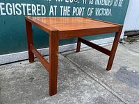 Side view highlighting the table frame and leg structure on concrete background.