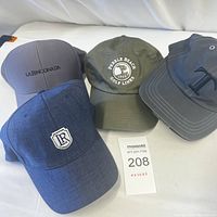 Four baseball caps arranged on white surface showing logos and colors