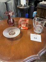 Top down view of four glass decorative items including the two Costa Boda candle holders on a wood table.