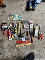 Lot overview displaying all included hand tools and accessories arranged on floor.