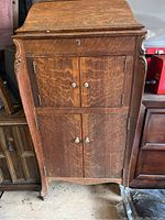 Front view of the wooden record player cabinet showing two sets of doors and keyhole on upper part.