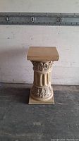 Full view of classic plaster pedestal showing height and ornate designs