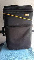 Front view of black Skyroll carry-on suitcase showing yellow diagonal accent and logo