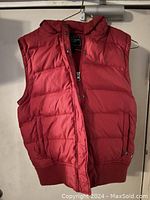 Front view of the American Eagle red puffer vest showing zipper, snap buttons, and ribbed waistband.