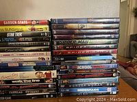Stack of 21 DVDs including Garden State, Miss Sunshine, Star Trek, Casino Royale, Spider-Man series, Pitch Perfect, Old School, Wonder Woman, Bridesmaids, and others.