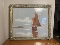 Full view of framed painting showing boat with brown sails and clouds in background, ornate carved frame.