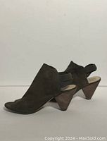 Side profile of left shoe showing olive suede material, slingback strap and wooden cone-shaped heel.