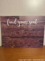 Wooden wedding sign with rustic wood background and white cursive text 'find your seat'.