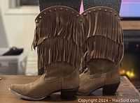 Side view of brown leather women's Durango cowboy boots showing fringes and studded tops.