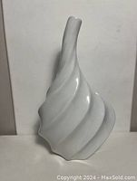 Front angle showing the swirl design and the shape of the white vase.