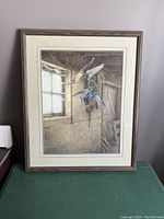 Framed print showing two birds flying inside a rustic barn with window light and wooden interior, matted and framed.