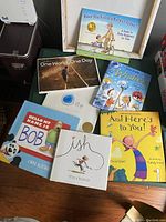 Lot of seven children's character building storybooks arranged on green table, showing front covers and partial stack of books
