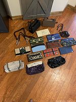 Full view of the 2 base purses and 13 interchangeable covers spread on the floor showing pattern and color variety
