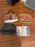 Four floral and colored tote-style purse bags shown on a wooden floor.