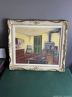 Front view of oil painting in the detailed ornate frame showing kitchen scene with stove and table.