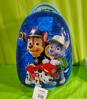 Front view of the blue hard shell suitcase with Paw Patrol characters Chase, Marshall, and Rocky printed on it.