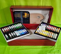 Full view of the open kit showing acrylic paints, brushes in case, palette, and painting tools inside the box.