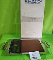 Full set laid out showing chrome tray with handles, teak cutting board and smaller black plastic tray with diamond pattern, alongside original box marked Kromex.