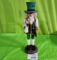 Front view of the wooden Irishman nutcracker showing full figure, green hat with clover, Irish flag, and violin.