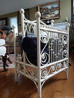 Side view showing open wicker magazine holder loaded with black rolled items