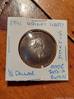 Front image of silver button made from 1941 Walking Liberty Half Dollar, showing Liberty figure and sun rays pattern.