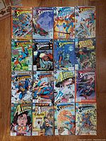 Overview of all sixteen vintage Superman comic books from 1990-1991 arranged in 4 rows on wooden floor