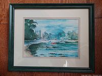Frontal view of the framed watercolour painting showing the coastal scene with boats and trees, double matted and under glass.