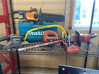 Worx electric chainsaw, Craftsman belt sander, electric hedge trimmer on metal shelf