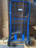 Front full view of the blue metal folding shopping cart showing the grid basket and frame