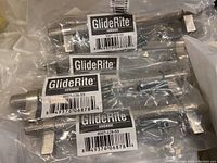 Close-up of GlideRite branded cabinet door handles still in sealed plastic packaging, showing the product labels and part number 8007-128-SS.