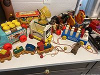 Full lot of vintage pull toys from Fisher-Price and Playskool, showing multiple colorful toys including Milk Wagon and Dairy Wagon.