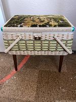 Closed sewing box showing woven wicker and velvet floral cushioned lid with wooden legs