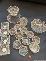 Photo showing the entire collection of vintage crystal and cut glass salt cellars, spoons, toothpick holder, and small bowl on a dark surface.