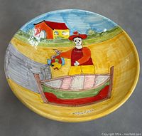 Top angled view of the large hand-painted Italian ceramic bowl showing the detailed colorful illustration and signature on the interior bottom.