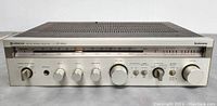 Front view of Hitachi SR-5010 FM-AM stereo receiver showing tuning dial, control knobs and switches on the aluminum front panel.