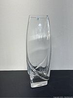 Front view of clear crystal vase showing its height, shape, and label sticker on top.