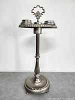 Full view of the vintage chrome stand showing height and ornamental details