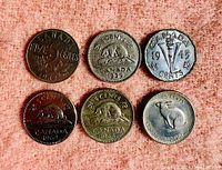 Reverse side of six Canadian nickels showing design including beaver (1932, 1939, 1964, 1967), torch (1945), and caribou (1969).